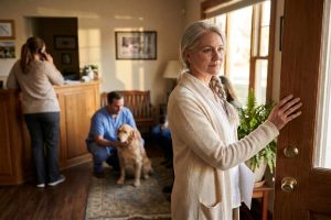 A veterinary practice owner standing in the doorway of her own clinic building, a printed property appraisal under her arm.